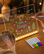 Child drawing on illuminated acrylic board with colorful markers